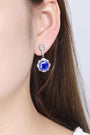 These S925 silver earrings have a fine clasp. Deep - blue gem encircled by diamonds in halo style, vivid color, circular form