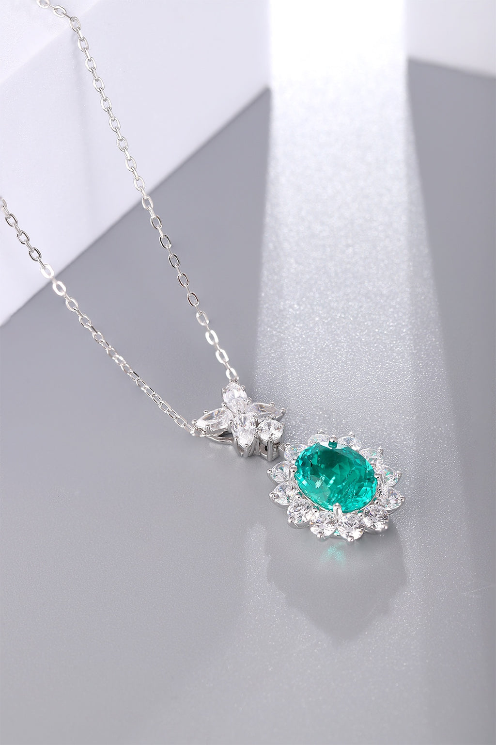 This S925 sterling silver necklace has a delicate design. Oval emerald with diamond halo, vibrant green, classic shape.
