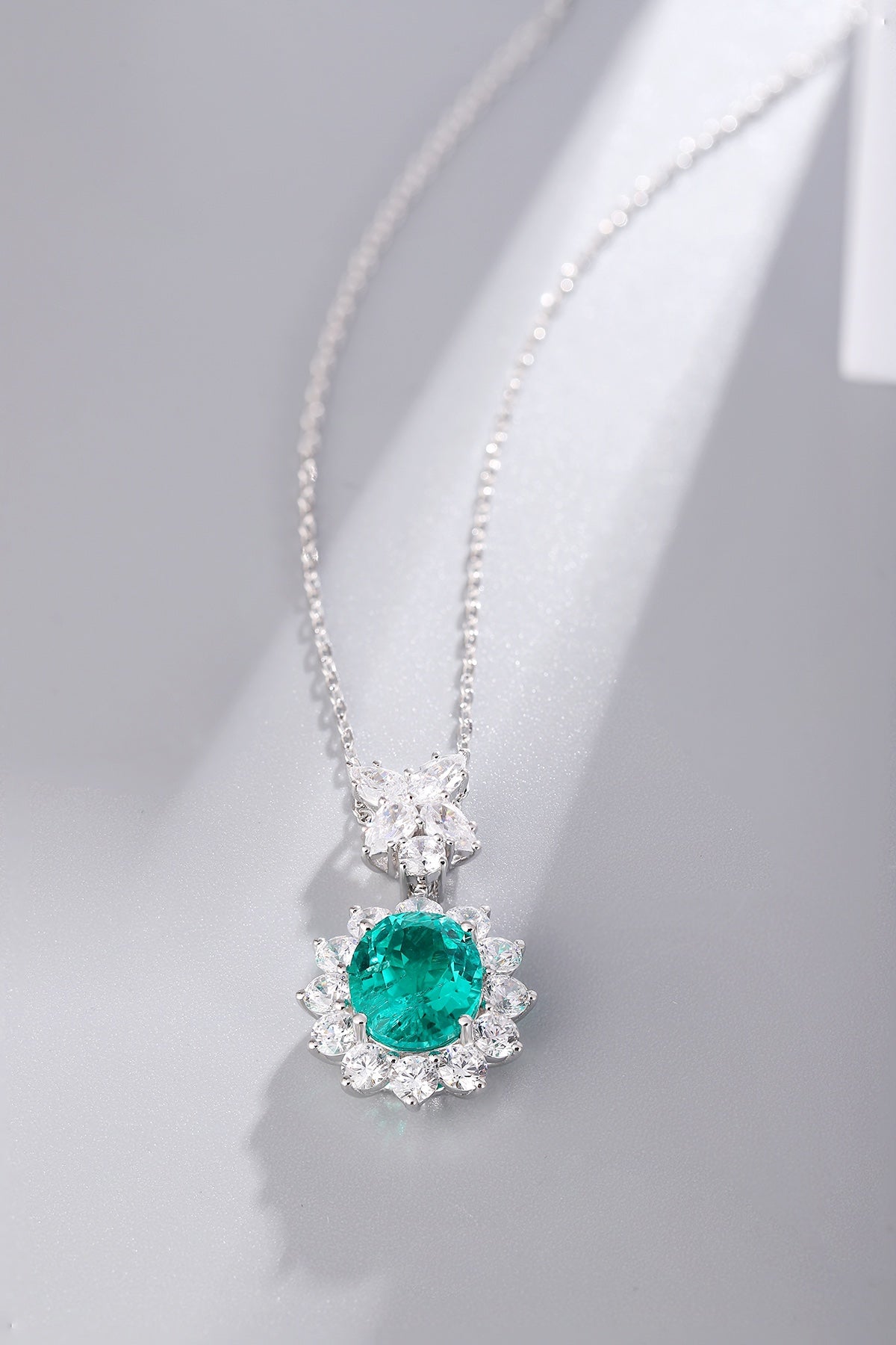 S925 silver necklace with a unique design. Oval emerald with diamond accents, deep green, graceful shape.
