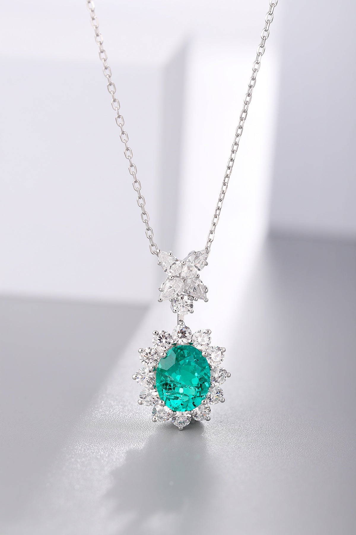 S925 silver necklace, chain and clasp well-crafted. Oval lab-grown emerald encircled by diamonds, lush green, charming shape.