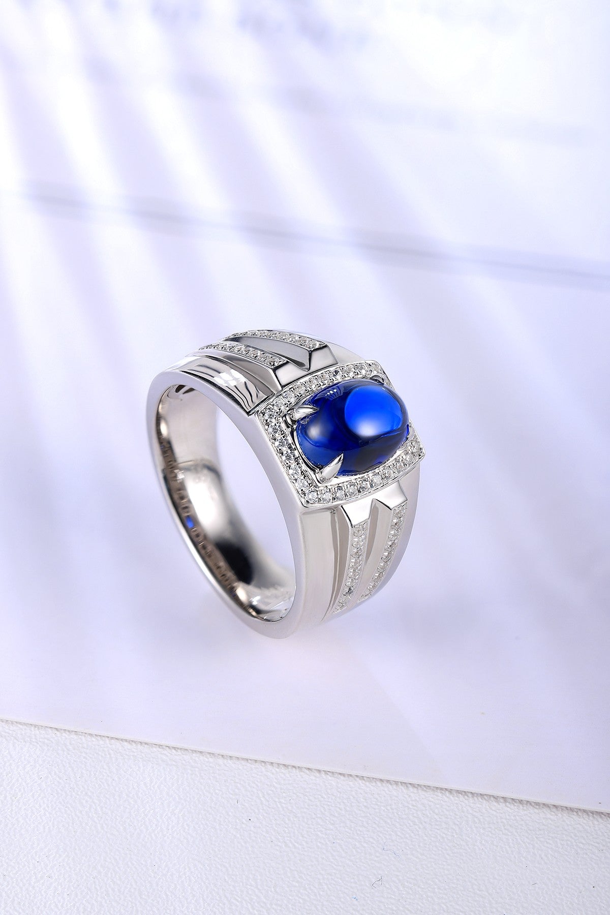 Open-end S925 silver ring, claw setting fixes oval sapphire. Pure blue, regular shape shows good texture.