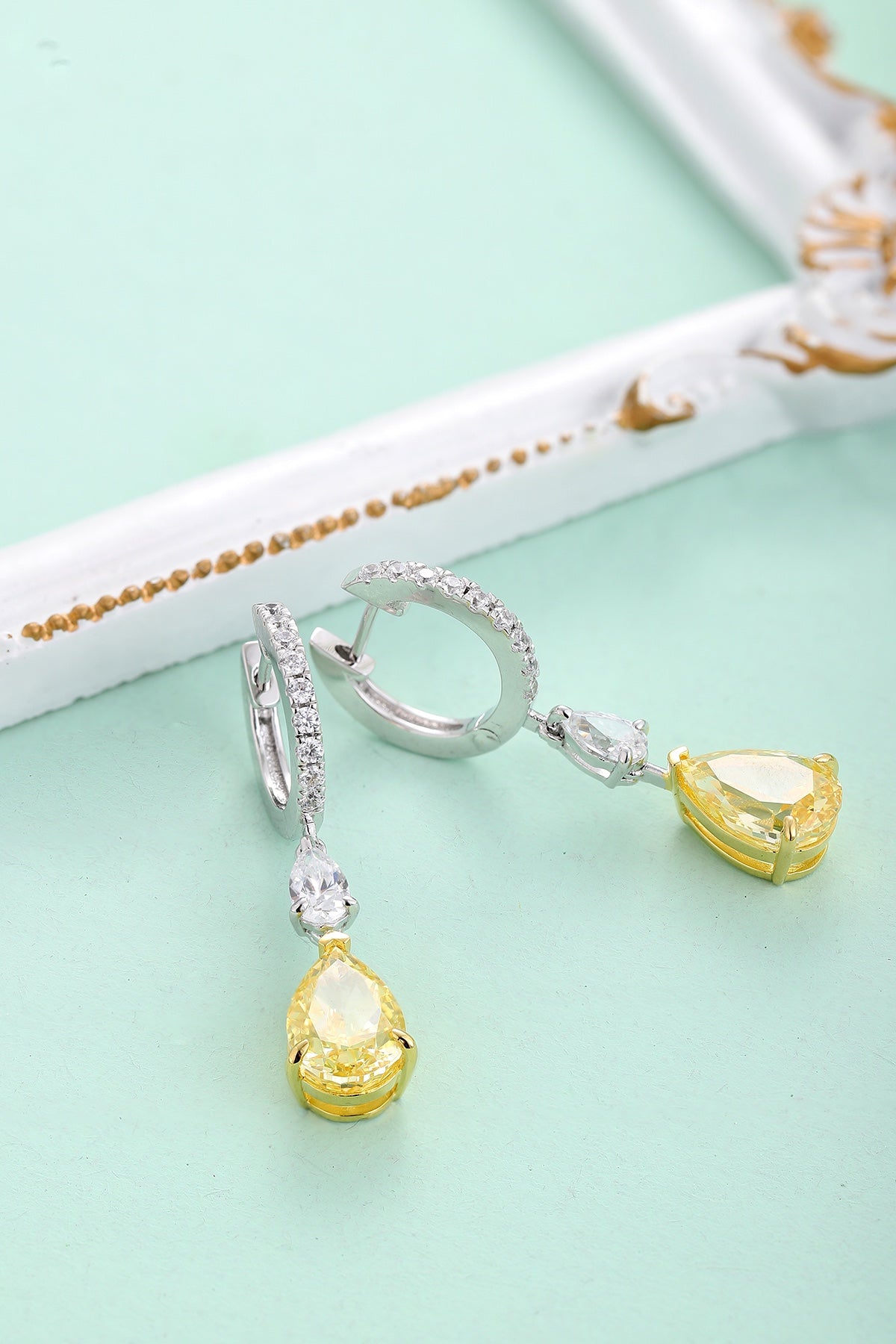 S925 silver earrings, well - made clasp. Feature clear and yellow gems, teardrop - like shape, charming design.