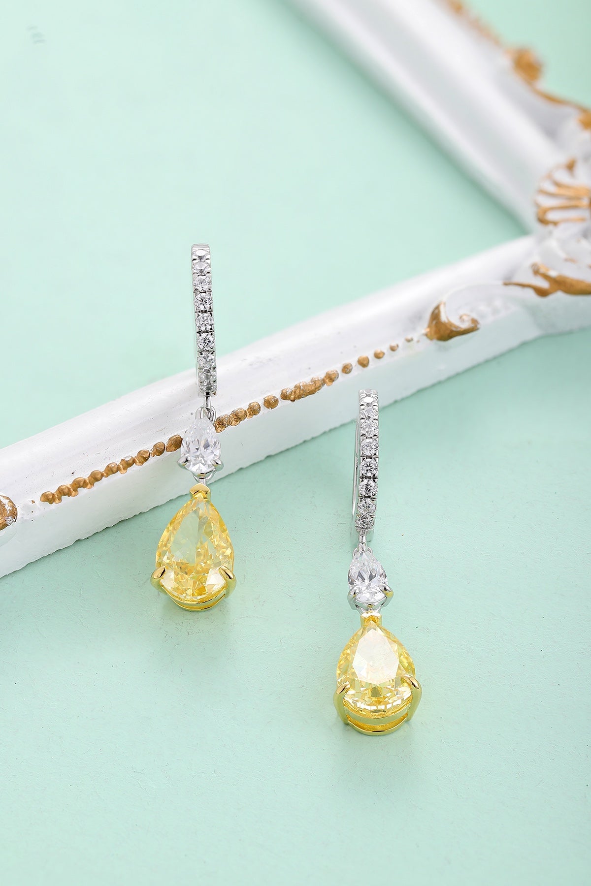 These S925 silver earrings have a fine clasp. Clear and yellow cubic zirconia in teardrop form, elegant design.
