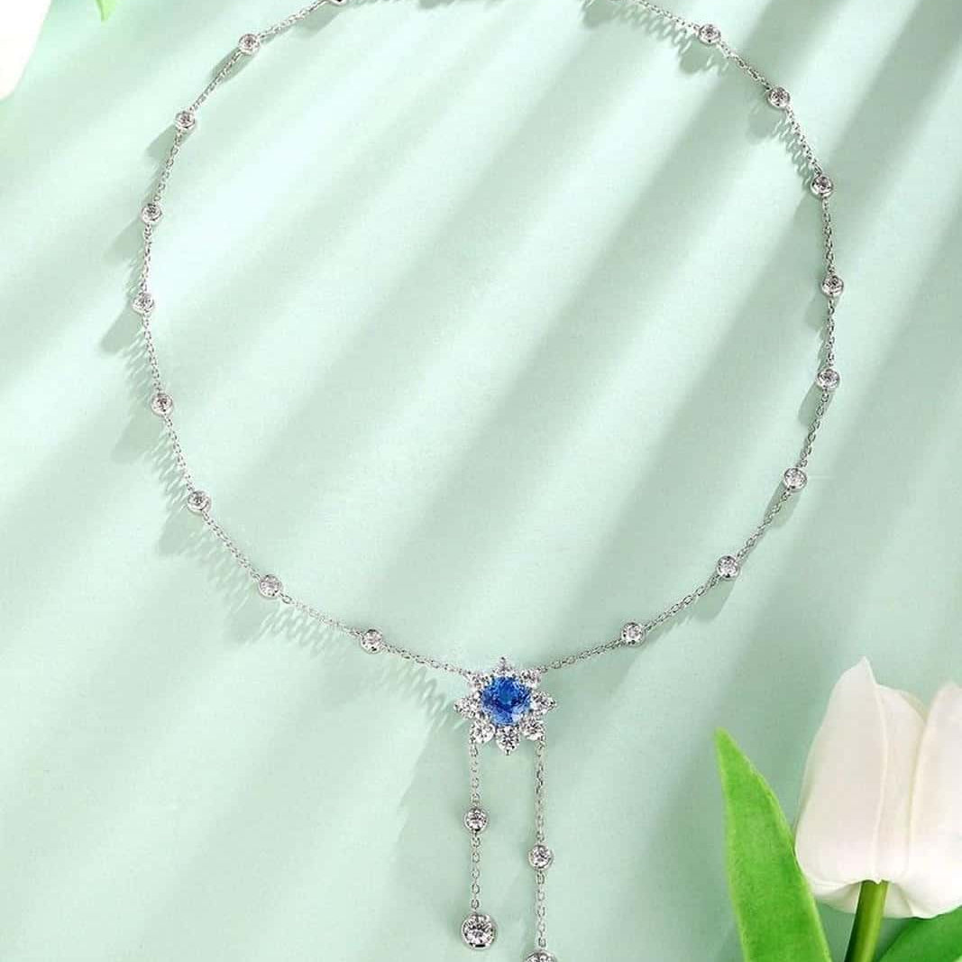 S925 silver pendant necklace with reliable clasp. Shows a flower-shaped deep-blue gem with dangling diamonds, stylish.
