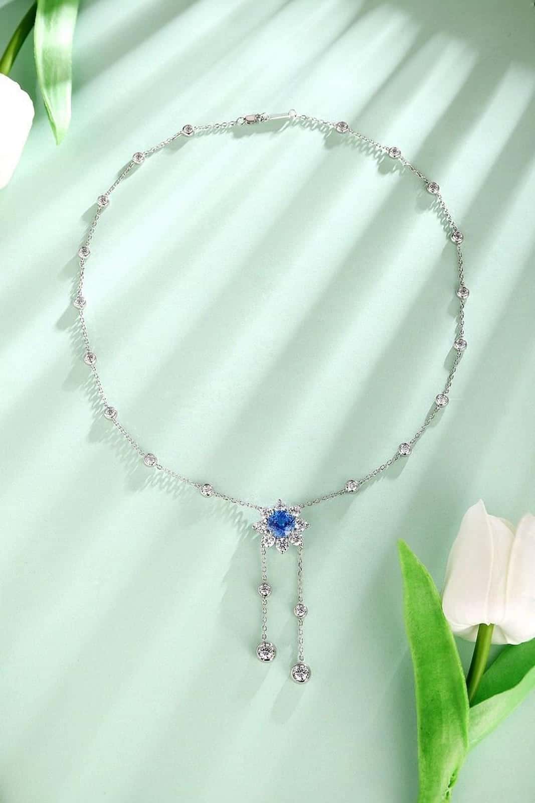 S925 silver pendant necklace with reliable clasp. Shows a flower-shaped deep-blue gem with dangling diamonds, stylish.