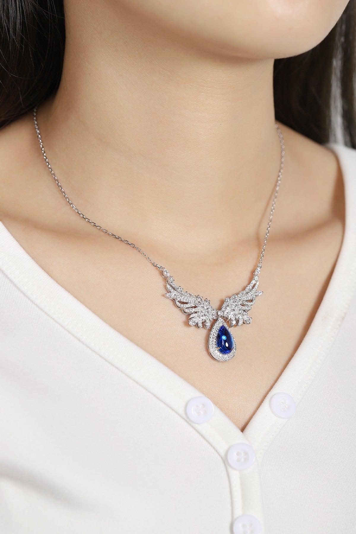 The silver chain (S925) has a delicate clasp, the wing-shaped diamond design with a teardrop blue stone exudes elegance.