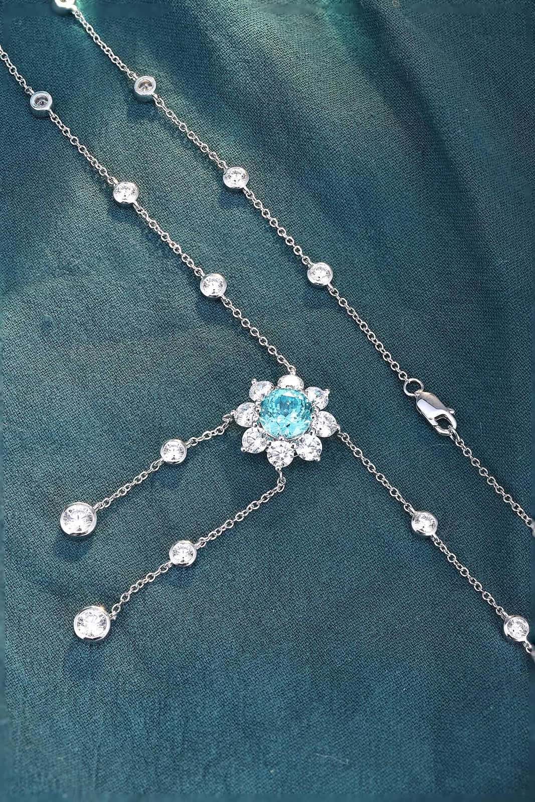 This S925 silver necklace has a secure clasp. Features a floral-designed light blue gemstone with diamond accents, charming s