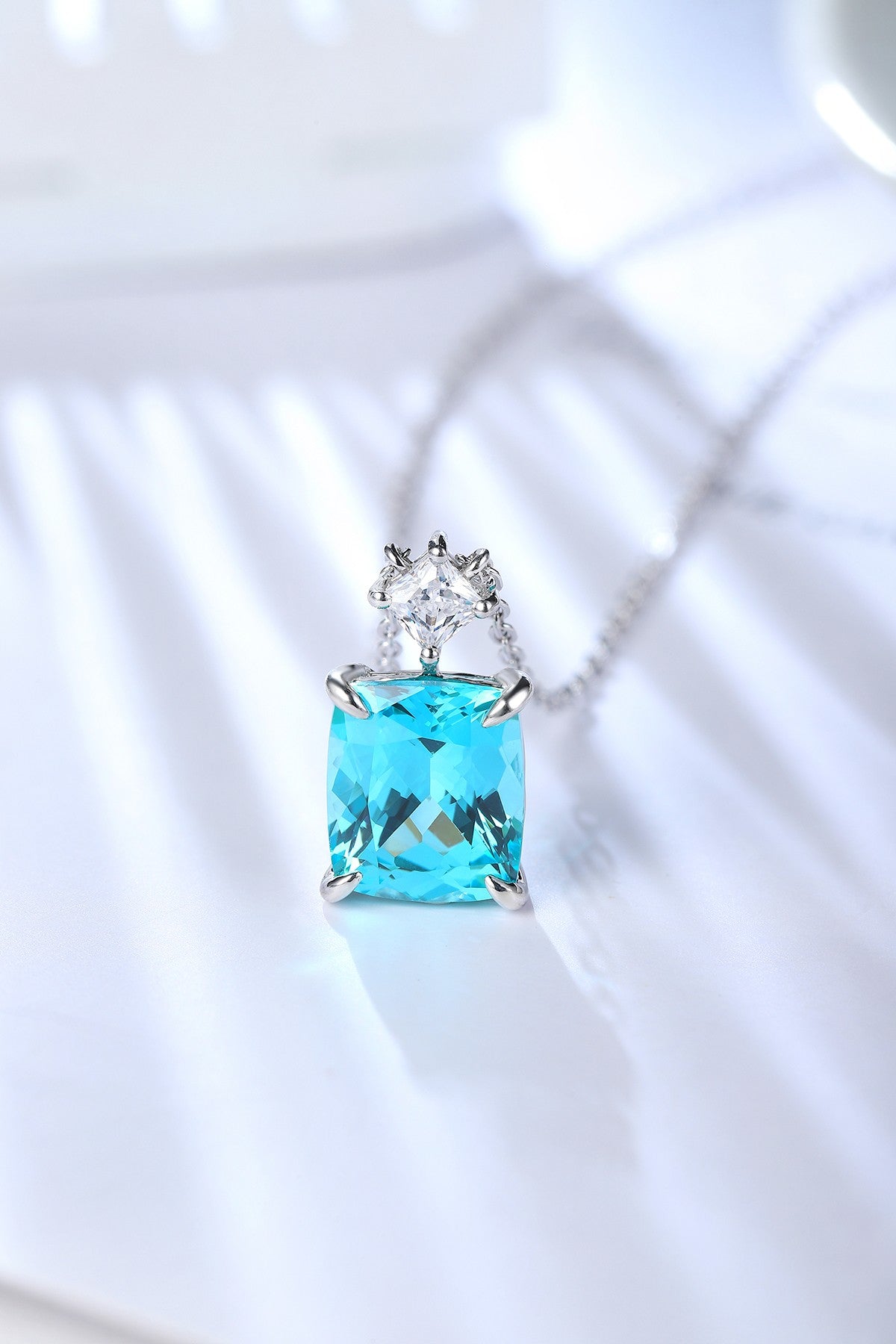 S925 silver necklace with fine clasp. Shows a square bright blue lab-grown Paraíba tourmaline and a small diamond, nice.