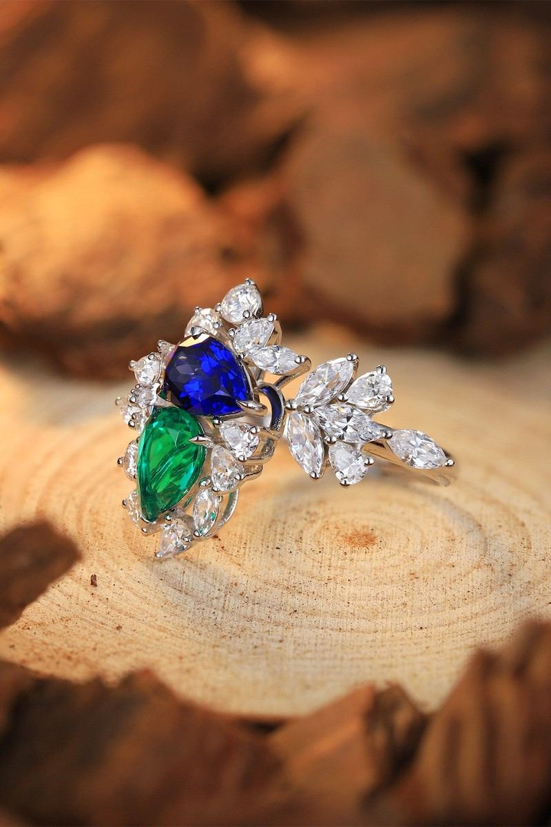 This S925 silver ring has a unique open design. The lab-grown emerald emits a charming green glow. Against the backdrop of ac