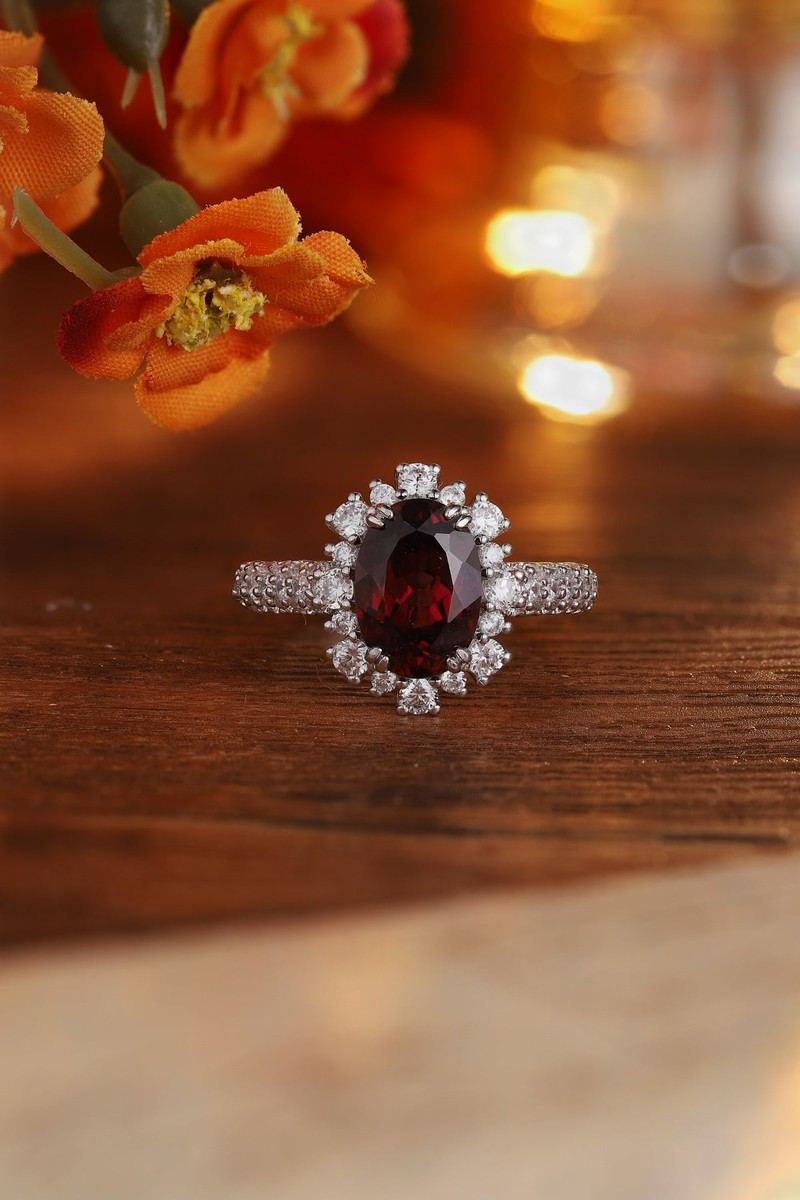 S925 silver ring with adjustable opening. Shows oval deep - red natural garnet surrounded by diamonds, stylish.