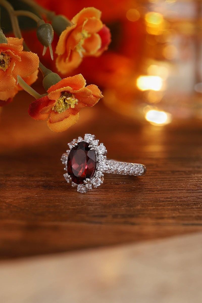 The S925 silver ring boasts an opening design. Deep - red gem with diamond halo, oval shape, comfortable fit.