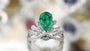 The ring surface is set with a lab-grown emerald, featuring rich and vivid color.