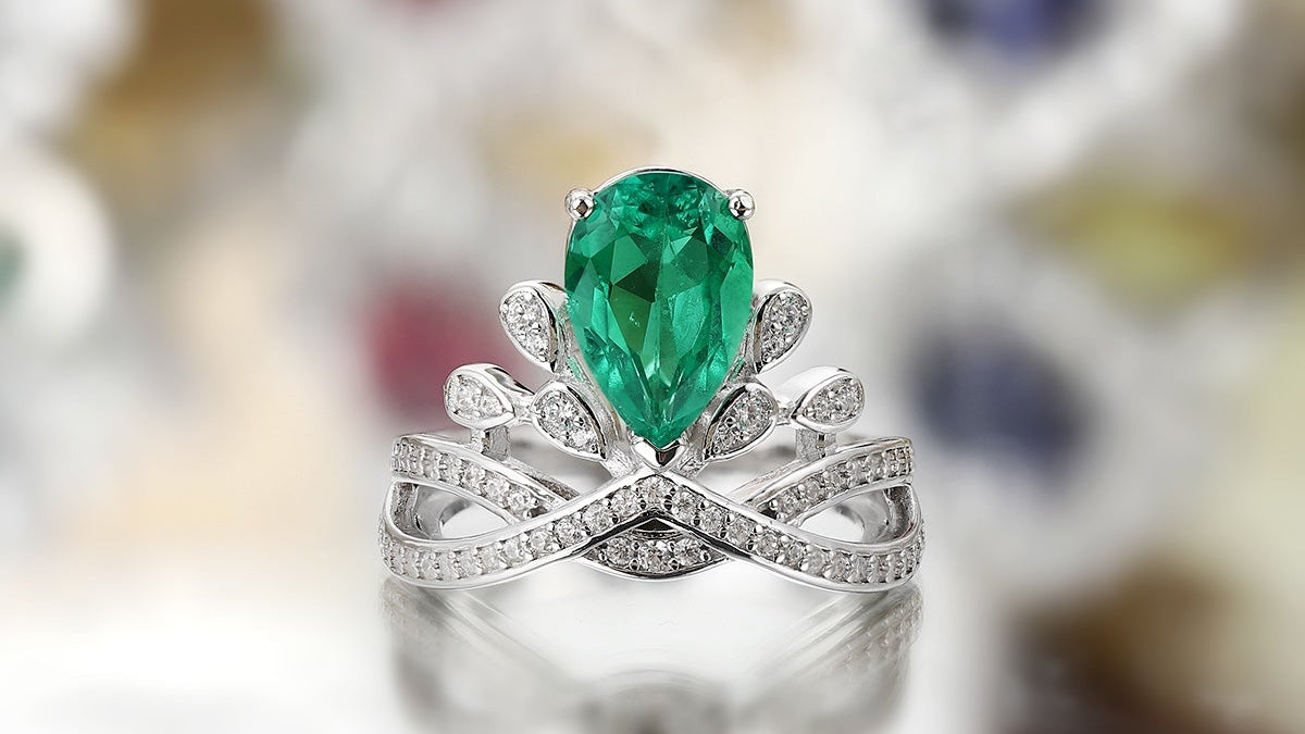 The ring surface is set with a lab-grown emerald, featuring rich and vivid color.