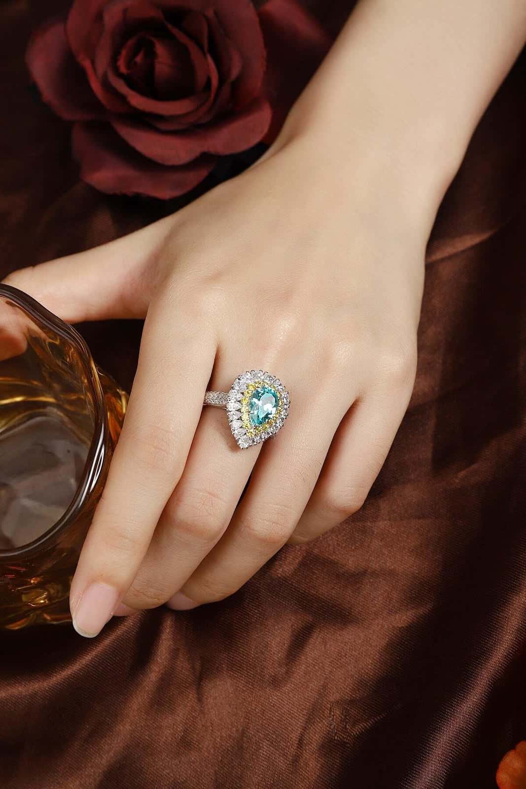 The S925 silver ring boasts a solid design. Shows a pear - shaped bright blue lab - grown gem with diamond and yellow diamond