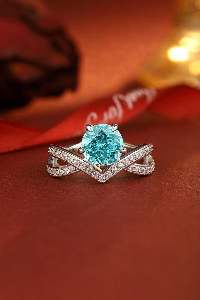 S925 silver ring featuring adjustable opening. Round lab - grown blue gem in V - shaped diamond - set cross - over, nice desi