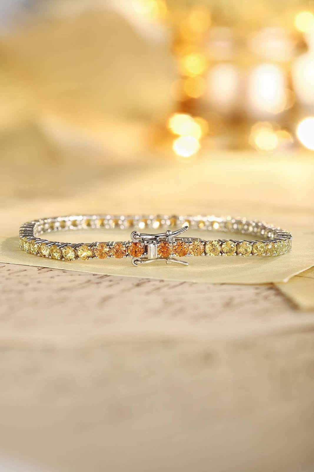 This bracelet is made of S925 silver with a delicate and durable clasp. The yellow-orange lab-grown colored sapphires are arr
